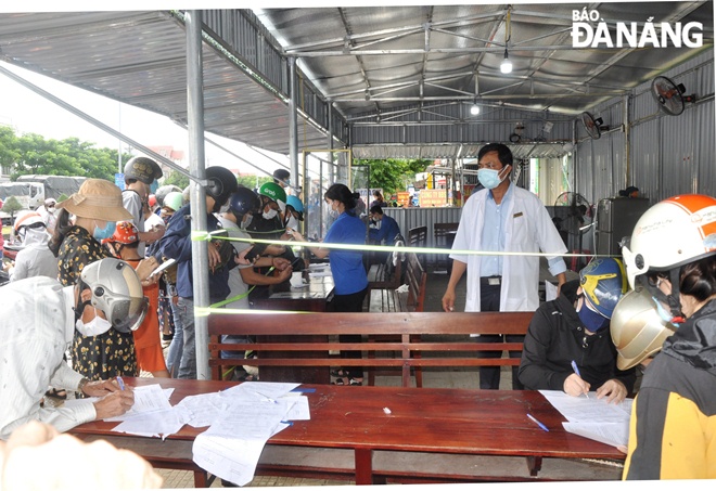 People are seen making mandatory medical declarations to be eligible to enter Quang Nam.