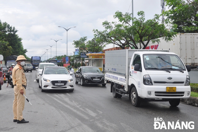 Traffic police directing vehicles at a checkpoints set up on Tran Dai Nghia Street, Ngu Hanh Son District, Da Nang