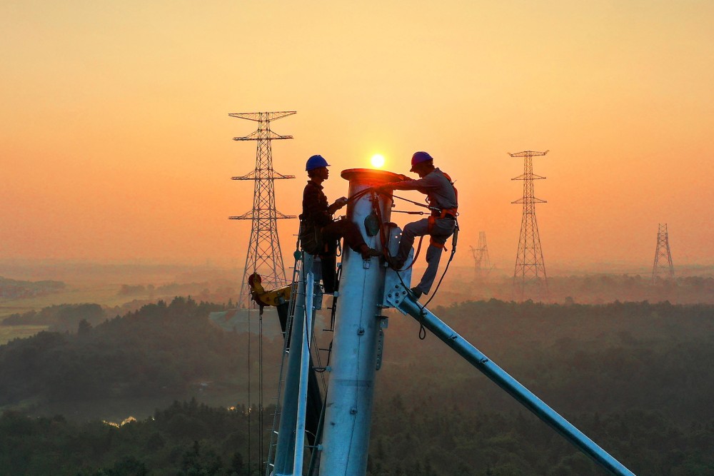 Các công nhân làm việc trên tháp truyền tải điện cao thế ở Nghi Xuân, tỉnh Giang Tây, miền trung Trung Quốc hôm 28/9. Ảnh: Getty Images