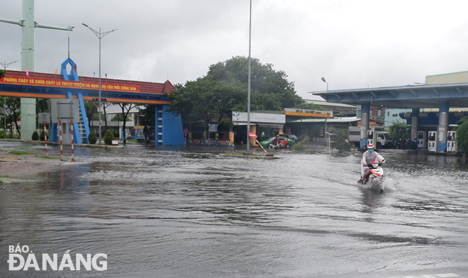 The area at the front of Hoa Khanh Industrial Park main gate located in Lien Chieu District is affected by flood water due to heavy rains. Photo: HOANG HIEP