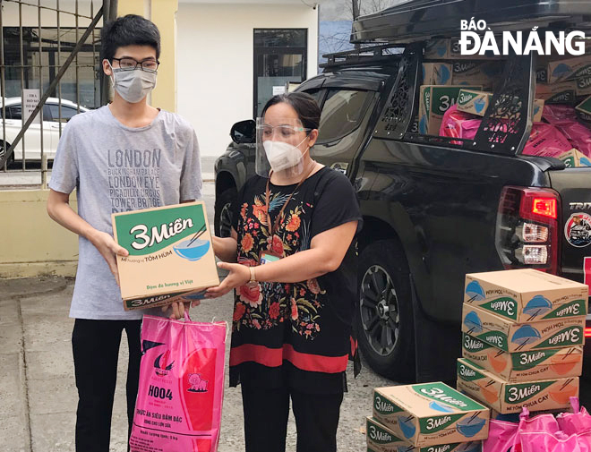 Ms. Truong Thi Nhu Hoa (right) giving a gift to a poor family in Thanh Khe Tay Ward, Thanh Khe District