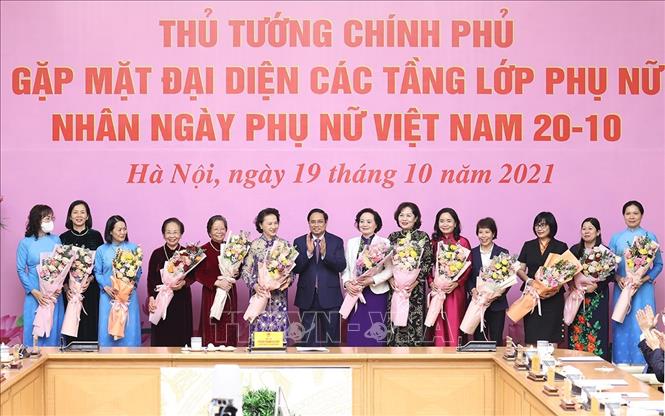 Thủ tướng Phạm Minh Chính tặng hoa chúc mừng các đại biểu phụ nữ tiêu biểu. Ảnh: Dương Giang/TTXVN