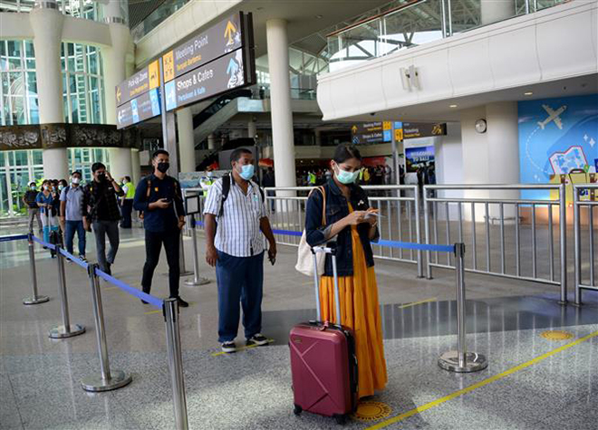 Hành khách tại sân bay quốc tế ở Tuban trên đảo Bali, Indonesia, ngày 14-10-2021. Ảnh: AFP/TTXVN
