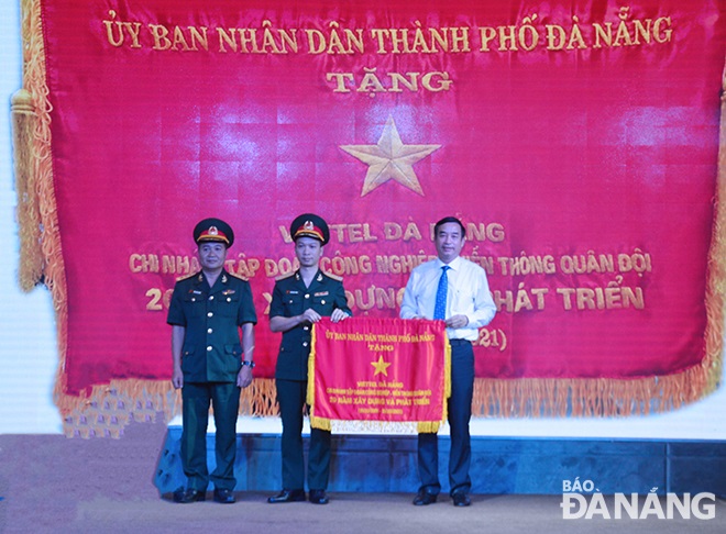 Da Nang People’s Committee Chairman Le Trung Chinh (right) presenting the Excellent Emulation Flag to a Viettel Da Nang representative