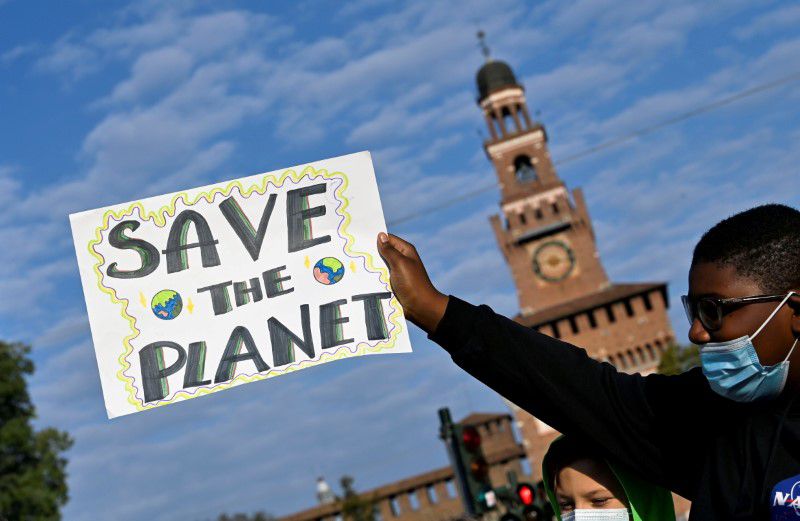 Một người biểu tình mang tấm biển có dòng chữ “Hãy cứu hành tinh” khi tham gia một cuộc đình công ở Milan (Ý) ngày 1-10. Ảnh: Reuters