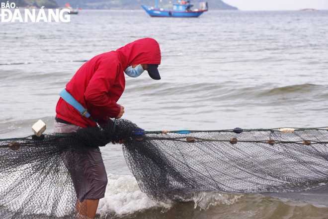 Fishermen have to tie a belt attached to the net to his back to concentrate traction to pull trawling nets ashore.