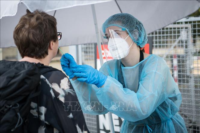 Nhân viên y tế lấy mẫu xét nghiệm COVID-19 tại Berlin, Đức. Ảnh: AFP/TTXVN