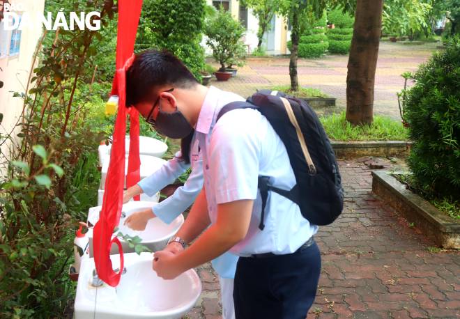 Students wash their hands and…