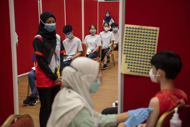Nhân viên y tế tiêm vaccine ngừa Covid-19 cho thanh thiếu niên tại Selangor, Malaysia. Ảnh: THX/TTXVN
