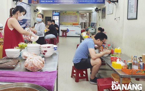 Một quán ăn trên đường Hùng Vương, phường Vĩnh Trung, bố trí chỗ ngồi bảo đảm giãn cách đúng quy định. Ảnh: XUÂN SƠN