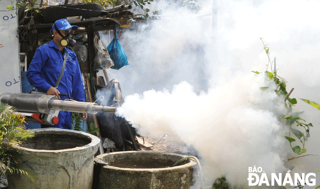 Nhân viên y tế quận Sơn Trà phun thuốc diệt bọ gậy, lăng quăng để phòng, chống bệnh sốt xuất huyết tại khu dân cư thuộc phường An Hải Đông.         				        Ảnh: LÊ HÙNG