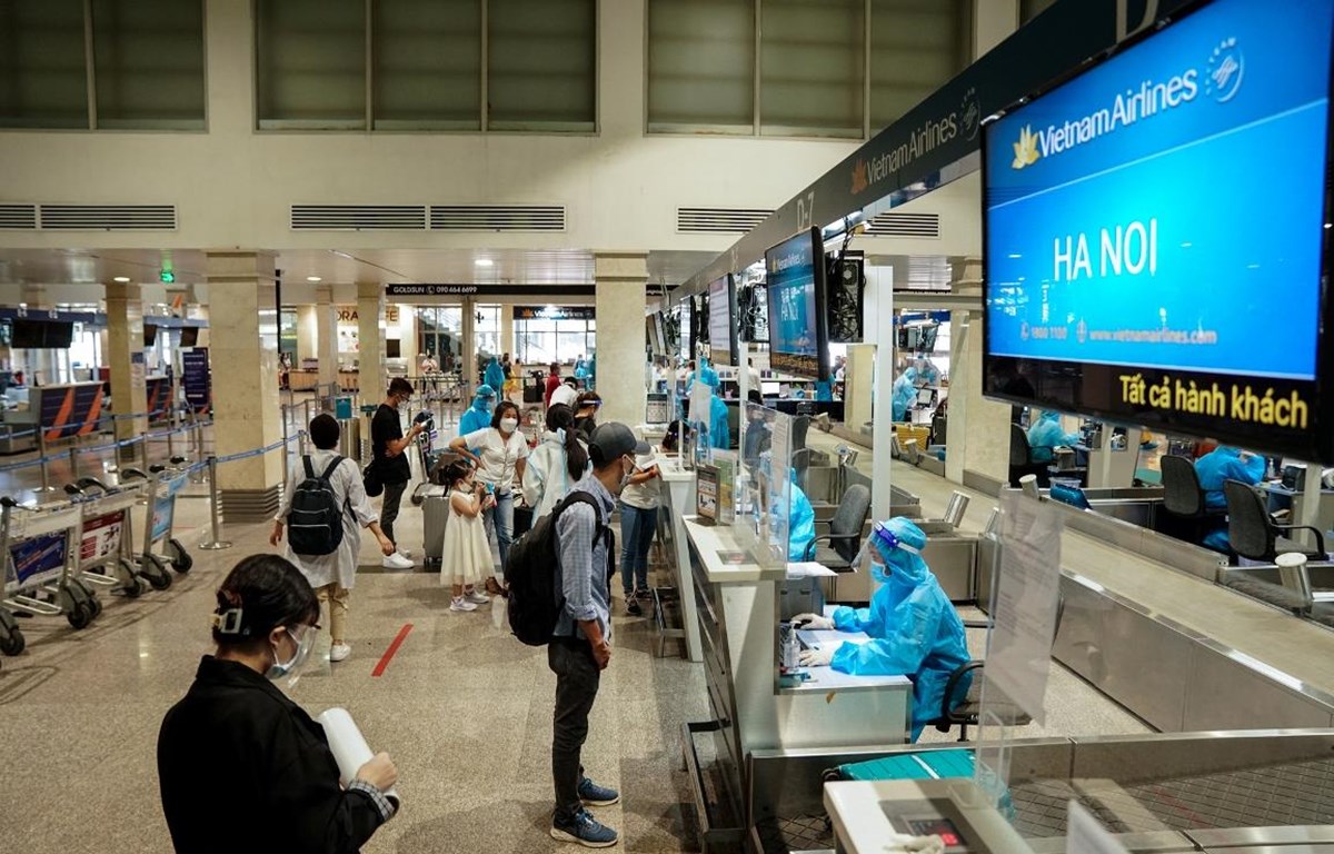 Hành khách Vietnam Airlines làm thủ tục ở quầy check-in sân bay Tân Sơn Nhất. (Ảnh: CTV/Vietnam+)