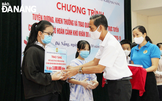 Nguyen Tran My Duyen, a 10th grader at Phan Thanh Tai Senior High School (first, left) receives online learning equipment under the 'Internet and computers for students' national campaign. Photo: TRA GIANG 