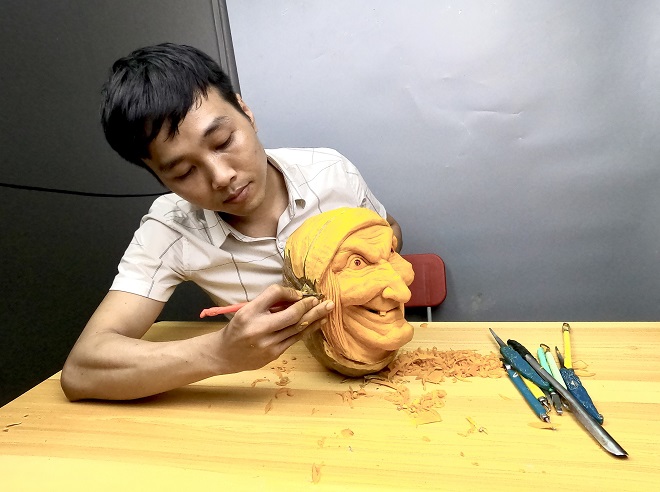 Mr. Nguyen Anh Vu shapes a pumpkin into a demon mask from for Halloween decoration. Photo: THANH TINH