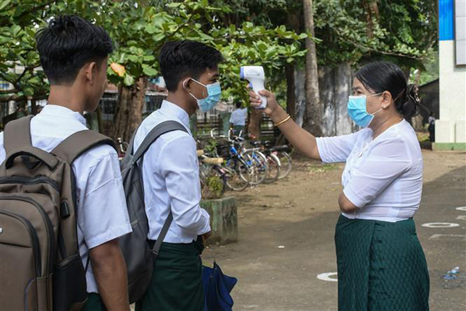  Kiểm tra thân nhiệt cho học sinh để phòng dịch Covid-19 tại trường học ở Sittwe, bang Rakhine, Myanmar, ngày 1-6-2021. Ảnh: AFP/TTXVN