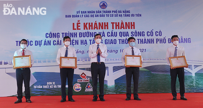 Chủ tịch UBND thành phố Lê Trung Chinh, trao Bằng khen của UBND thành phố cho tổ chức có thành tích tốt trong quá trình thi công dự án. Ảnh: THÀNH LÂN