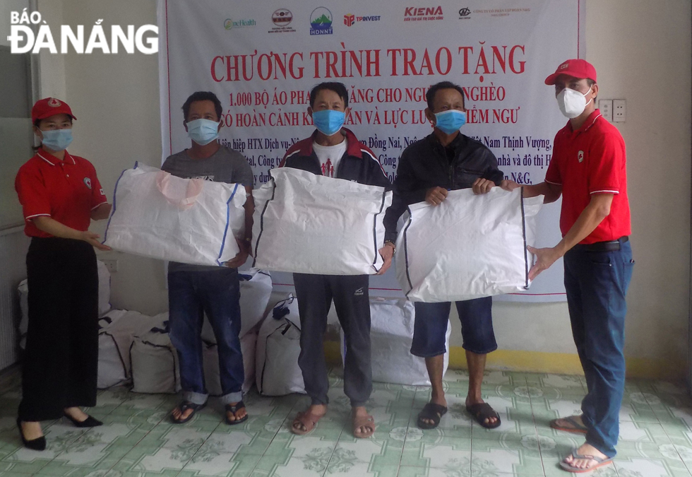 Staff of the Da Nang Red Cross Society presenting multifunctional life jackets to fishermen