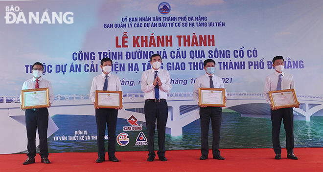 Chairman Chinh awarded certificates of merit from the municipal government to the units for their dedication and commitment to the project. Photo: THANH LAN