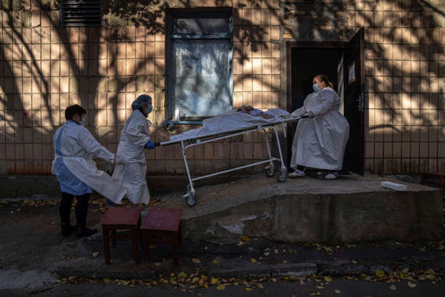Nhân viên y tế vận chuyển thi thể một bệnh nhân tử vong vì COVID-19 tại Kiev, Ukraine. Ảnh: AP