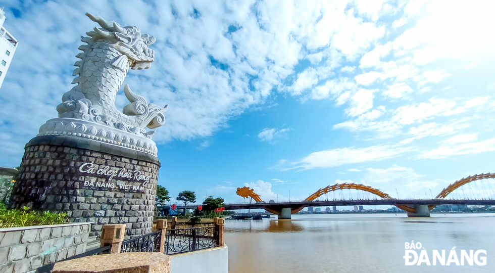 The 'Carp Turns into a Dragon' statue and the Dragon Bridge stand out dramatically against the blue sky.