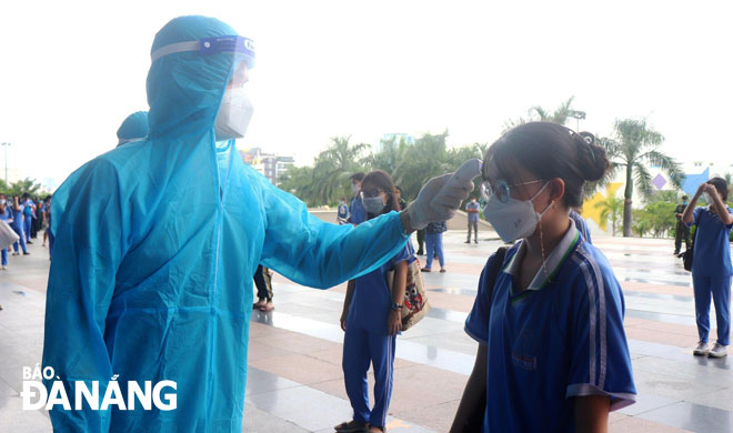 Eligible students have their temperature checked before entering the vaccination site.