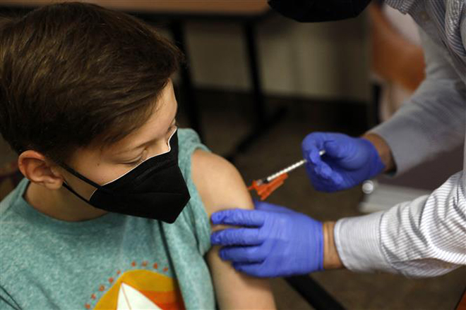 Nhân viên y tế tiêm vaccine ngừa Covid-19 cho trẻ em tại Bloomfield Hills, bang Michigan, Mỹ. Ảnh: AFP/TTXVN