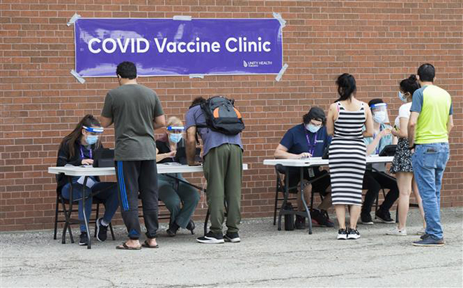 Người dân đăng ký tiêm vaccine phòng Covid-19 tại Toronto, Canada, ngày 26-5-2021. Ảnh: THX/ TTXVN