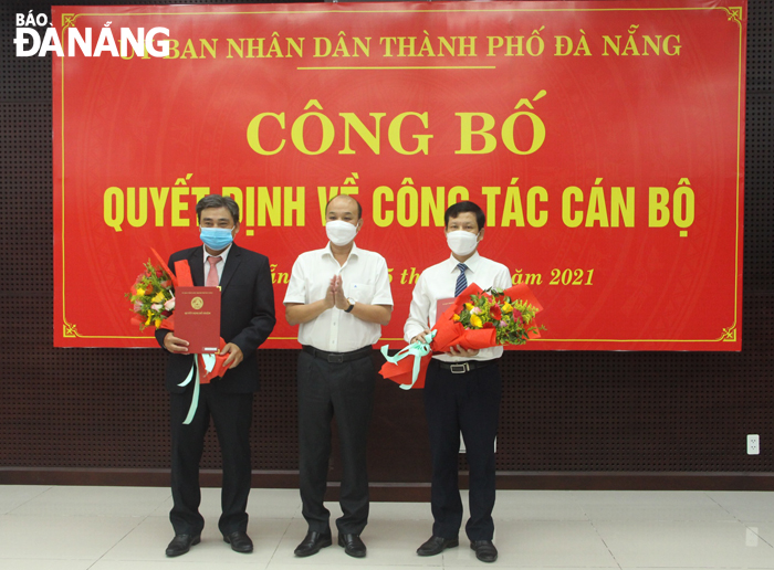 Phó Chủ tịch UBND thành phố Lê Quang Nam (đứng giữa) trao quyết định và tặng hoa chúc mừng tại lễ công bố. Ảnh: T. HUY