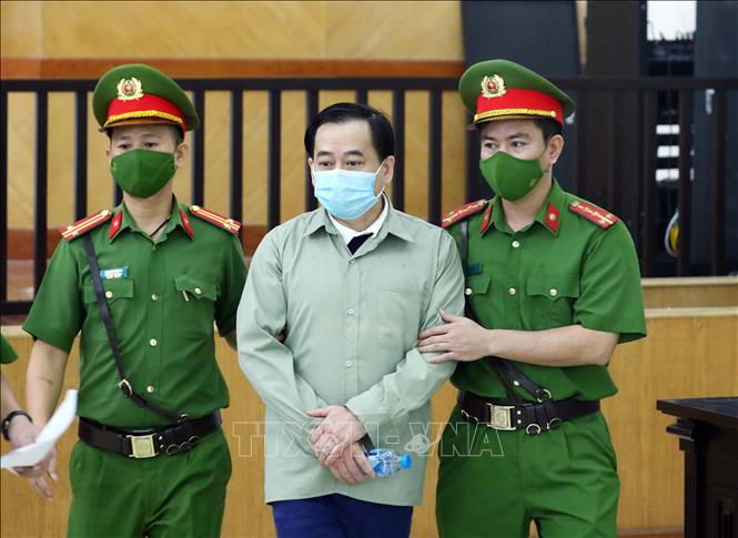 Lực lượng chức năng dẫn giải bị cáo Phan Văn Anh Vũ đến phiên tòa xét xử. Ảnh: Phạm Kiên/TTXVN
