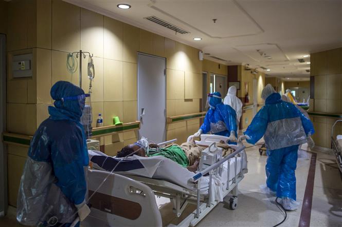 Nhân viên y tế chuyển bệnh nhân nhiễm COVID-19 tới bệnh viện ở Surabaya, Đông Java, Indonesia. Ảnh: AFP/TTXVN