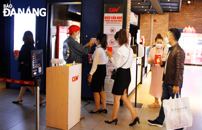 People will have their temperatures checked and their QR codes scanned before entering film screening rooms, as well as are encouraged to book tickets online and use electronic movie tickets to limit contact. IN PHOTO: Cinema-goers are seen at the CGV Vincom Cinema in Da Nang. Photo: XUAN DUNG