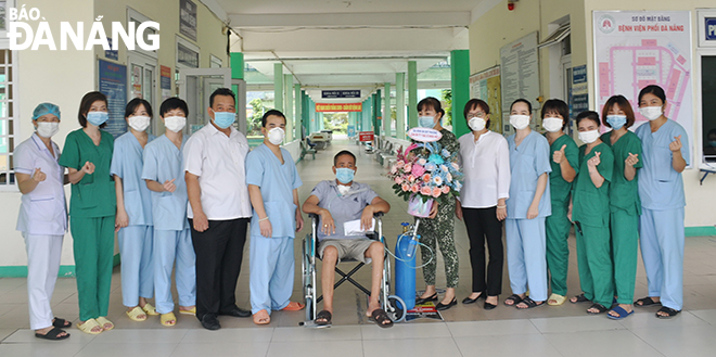 Doctor Le Thanh Phuc, the Director of the Da Nang Lung Hospital, the only one medical establishment in the city designated for COVID-19 treatment (fifth from left) congratulate those who are discharged from the hospital following recovery from the coronavirus