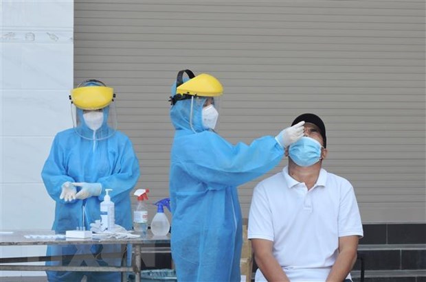  A health worker takes a sample from a man for COVID-19 test. (Photo: VNA)