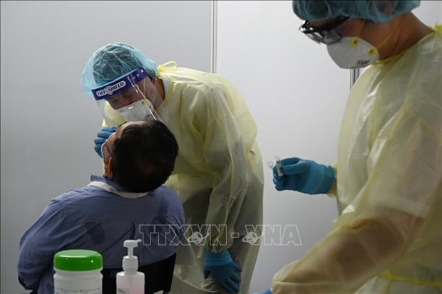 Medical workers collect swab sample for COVID-19 testing (Photo: AFP/VNA)