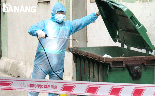 The hazardous waste with a high risk of containing SARS-CoV-2 viruses is strictly collected, transported and processed to ensure safety for pandemic prevention and control. Photo: A janitor is spraying disinfectant on dust carts containing potentially hazardous wastes of SARS-CoV-2 in Lien Chieu District. Photo: VAN HOANG