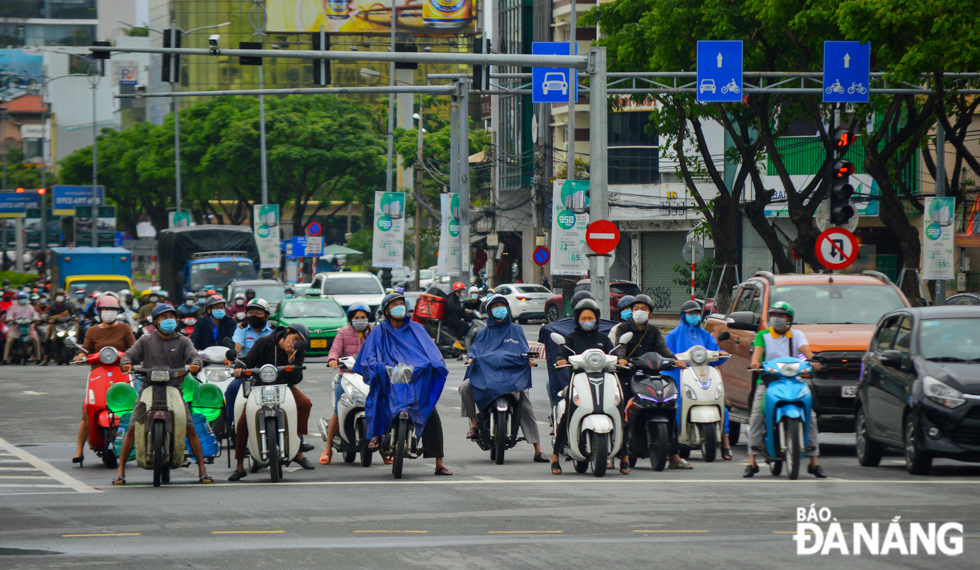 Many people are seen wearing coats and raincoats as going out to the street. Photo taken on Nguyen Van Linh Street.