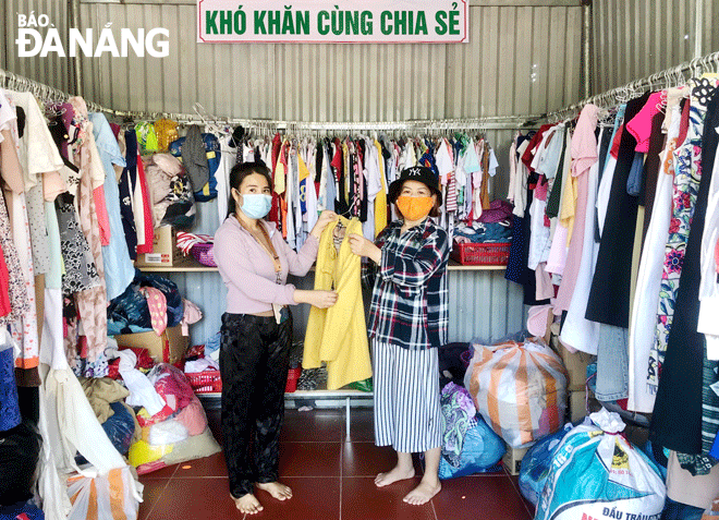 Ms. Le Thi Hoang Ngan (left) in Hoa Minh Ward, Lien Chieu District helps a needy woman choose warm clothes from her ‘Zero-dong clothing stall’ Photo: N. QUANG