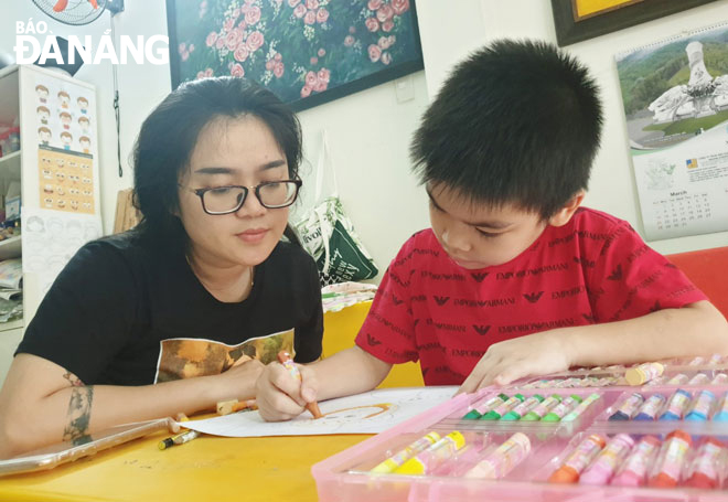 Văn Thị Tường Vy (31 tuổi, quận Sơn Trà) hướng dẫn học sinh học vẽ tại lớp vẽ Nhí nhố. Ảnh: ĐAN TÂM