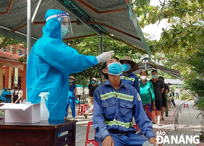 Lực lượng y tế lấy mẫu xét nghiệm người dân trên địa bàn quận Sơn Trà khi địa phương liên tục ghi nhận nhiều ca mắc Covid-19 mới. Ảnh: PHAN CHUNG