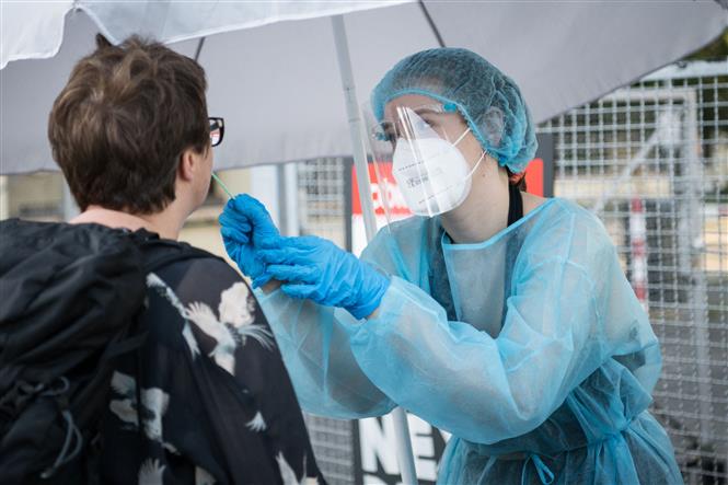 Nhân viên y tế lấy mẫu xét nghiệm COVID-19 cho người dân tại Kreuzberg, Berlin, Đức ngày 30-7-2021. Ảnh: AFP/TTXVN