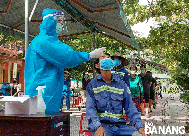 Healthcare workers taking nasal swab samples of residents in Son Tra District for COVID-19 amid a rise in cases. Photo: PHAN CHUNG