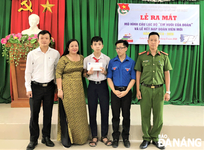 Bí thư Đoàn phường Hòa Khánh Nam (quận Liên Chiểu) Nguyễn Ngô Hoàng Long (bìa trái) cùng đại diện Trường THCS Ngô Thì Nhậm trao kinh phí hỗ trợ cho em Phạm Nguyễn Minh Khanh (giữa). (Ảnh chụp thời điểm không có Covid-19) Ảnh: H.H	