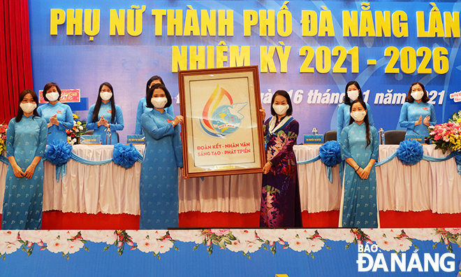 Phó Chủ tịch Hội Liên hiệp Phụ nữ Việt Nam Bùi Thị Hòa tặng logo Trung ương Hội cho đại hội. Ảnh: XUÂN DŨNG