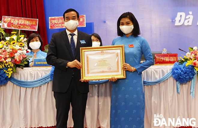  Da Nang Party Committee Deputy Secretary cum municipal People's Committee Chairman Le Trung Chinh awards a certificate of merit from the Prime Minister to an individual for her outstanding achievements during the 2016 – 2021 term. Photo: XUAN DUNG