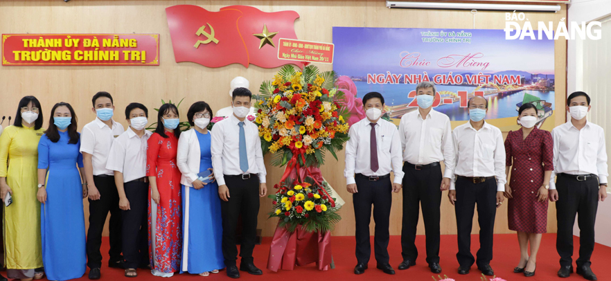 Da Nang Party Committee Deputy Secretary cum municipal People's Council Chairman Luong Nguyen Minh Triet (fifth from right) congratulates the staff and lecturers of the Da Nang School of Politics on the occasion of Vietnamese Teachers' Day. Photo: NGOC PHU