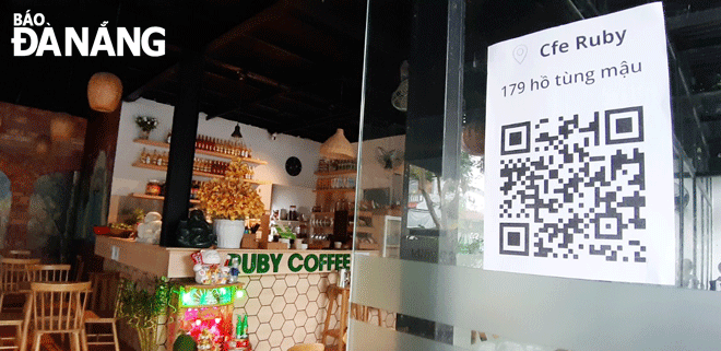 Quán cà phê Ruby trên đường Hồ Tùng Mậu dán mã QR ngay cửa chính để nhắc nhở khách hàng về việc quét mã khi vào hàng quán. Ảnh: T.V