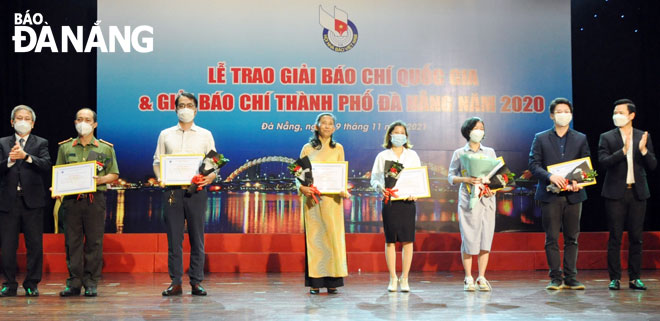 Phó Trưởng Ban Thường trực Ban Tuyên giáo Thành ủy Đoàn Xuân Hiếu (ngoài cùng, bên phải) và Giám đốc Sở Thông tin và Truyền thông Nguyến Quang Thanh (ngoài cùng, bên trái) trao giải nhi cho các tác giả, nhóm tác giả đoạt giải Báo chí thành phố năm 2020. Ảnh: LÊ HÙNG