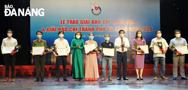 Da Nang Party Committee Deputy Secretary cum municipal People's Council Chairman Luong Nguyen Minh Triet (fourth, right), and People’s Committee Vice Chairwoman cum Head of the organising board of this year’s Press Awards Ngo Thi Kim Yen (fourth left) presenting  prizes to first-prize winners at the Da Nang Press Awards 2020. Photo: LE HUNG