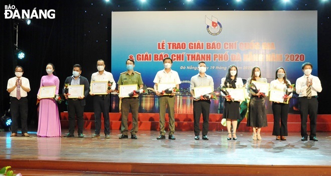 Vice Chairman of the municipal Journalists’ Association cum Deputy Director of the Da Nang Radio and Television Station Hong Quang Nam (first left) and Lieutenant Colonel Nguyen Quang Sang (first right) awarding consolation prizes to authors and groups of authors. Photo: LE HUNG