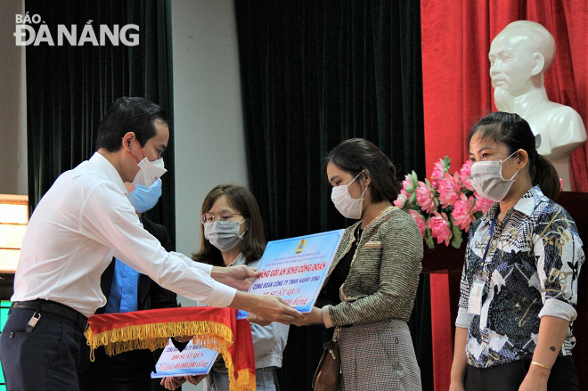 Municipal Labour Confederation Chairman Nguyen Duy Minh (in white) presenting 